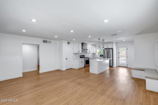 2336 E Flower St, Phoenix, AZ 85016 - kitchen with appliances with stainless steel finishes, wall chimney range hood, open floor plan, recessed lighting, and light wood-style floors