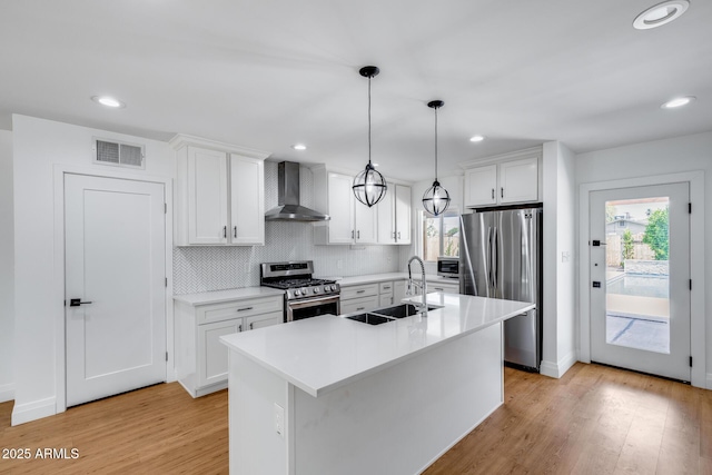 2336 E Flower St, Phoenix, AZ 85016 - kitchen featuring appliances with stainless steel finishes, wall chimney range hood, a sink, healthy amount of natural light, and recessed lighting