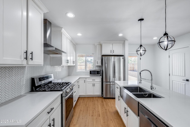 2336 E Flower St, Phoenix, AZ 85016 - kitchen with stainless steel appliances, wall chimney range hood, a sink, light countertops, and white cabinetry