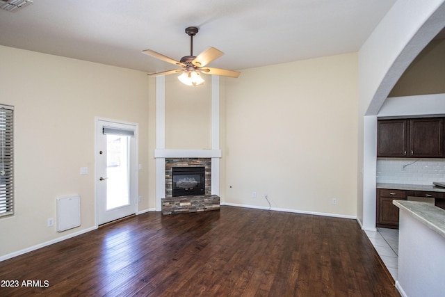 unfurnished living room with ceiling fan, light wood-type flooring, and a fireplace