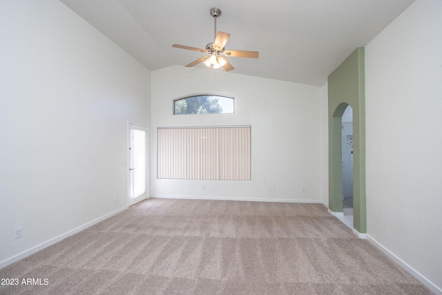 carpeted empty room with high vaulted ceiling and ceiling fan