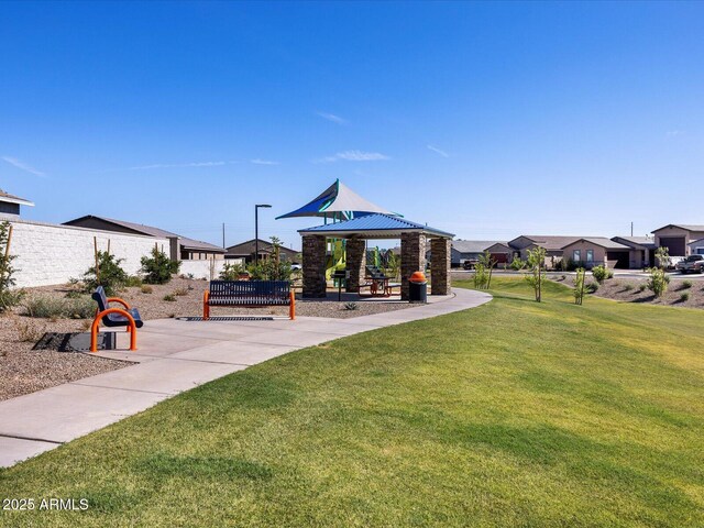 view of home's community with a yard, fence, a residential view, and playground community