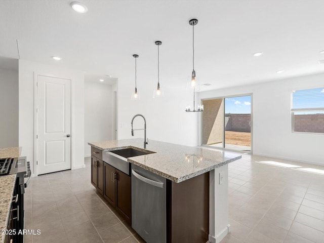 kitchen featuring a sink, a center island with sink, open floor plan, appliances with stainless steel finishes, and light tile patterned floors