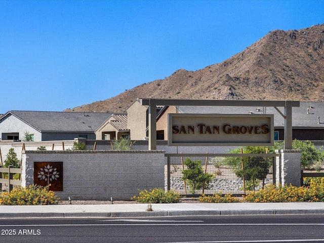 community / neighborhood sign featuring a mountain view and fence