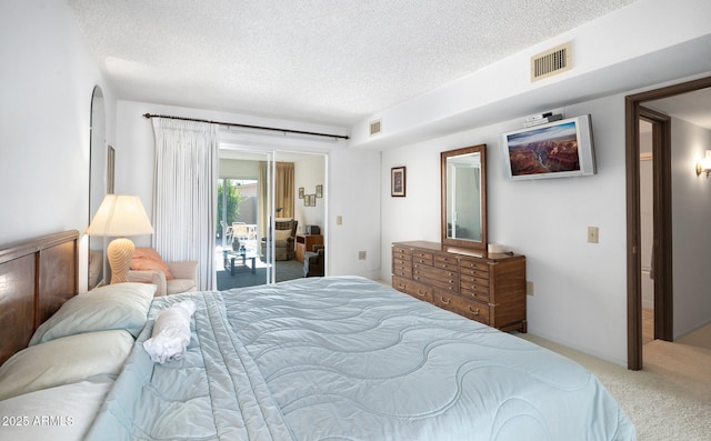 carpeted bedroom with access to exterior and a textured ceiling