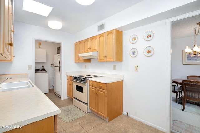 kitchen with white appliances, sink, decorative light fixtures, a chandelier, and washer / clothes dryer