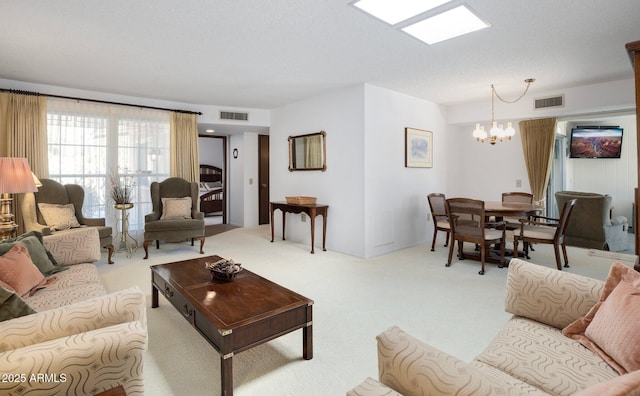 carpeted living room with a notable chandelier