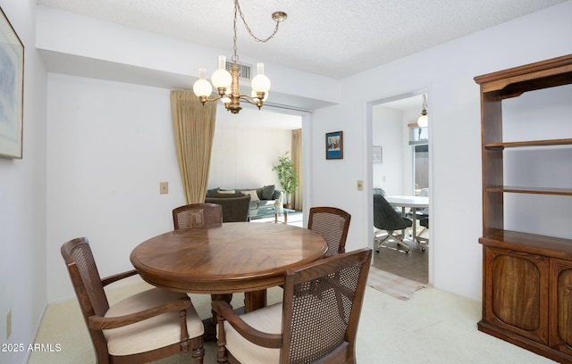 dining room with light carpet, a textured ceiling, and an inviting chandelier