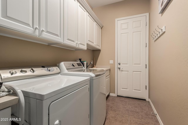 laundry room with light tile patterned flooring, cabinets, and washer and clothes dryer