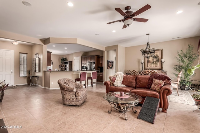 living room with ceiling fan with notable chandelier and light tile patterned flooring