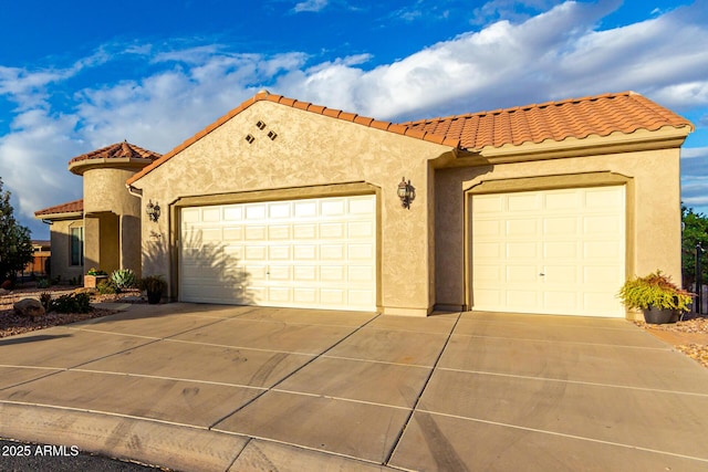 mediterranean / spanish home with stucco siding, concrete driveway, a tile roof, and a garage