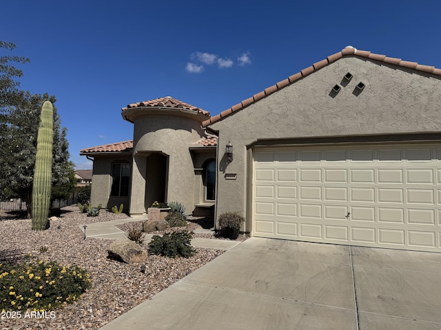 mediterranean / spanish home with a tiled roof, stucco siding, driveway, and a garage