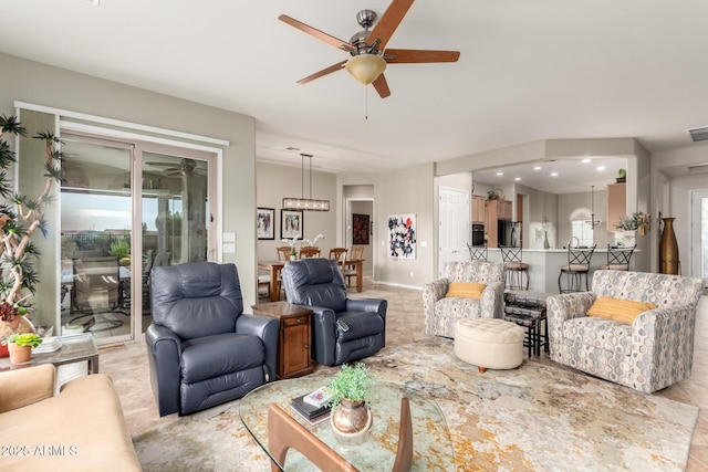 living room with visible vents, baseboards, and ceiling fan