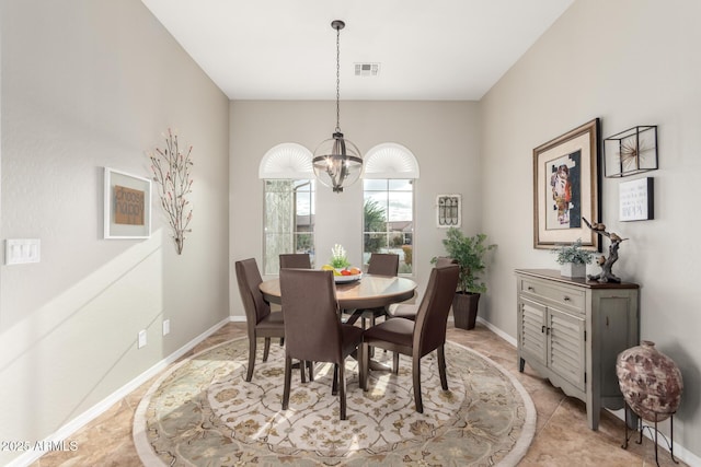 dining room with a notable chandelier, visible vents, and baseboards