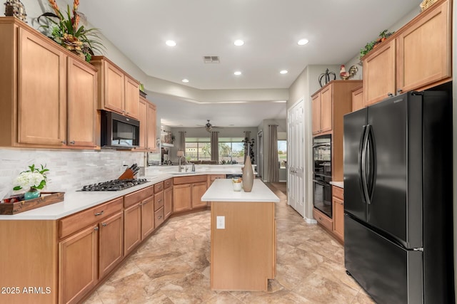 kitchen featuring visible vents, light countertops, a peninsula, black appliances, and a sink