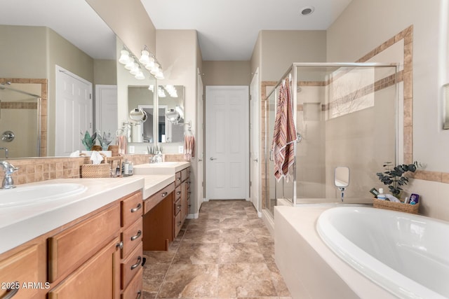 bathroom with a garden tub, double vanity, a stall shower, and a sink