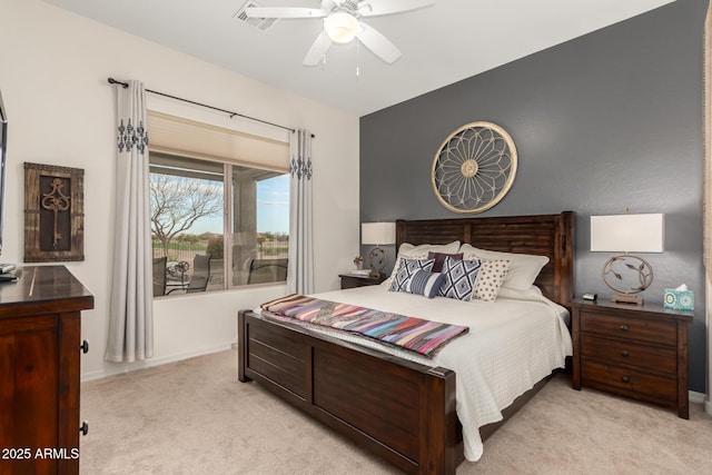 bedroom with visible vents, light colored carpet, and a ceiling fan