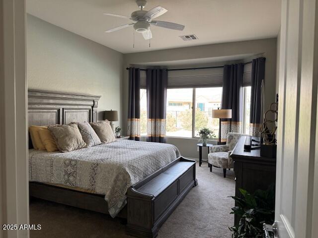 carpeted bedroom featuring visible vents and ceiling fan