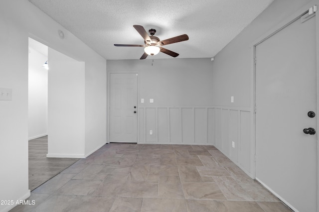 unfurnished room featuring ceiling fan and a textured ceiling