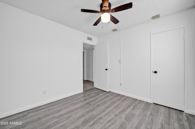 unfurnished bedroom with a textured ceiling, light hardwood / wood-style floors, and ceiling fan