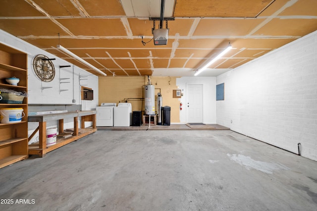 garage featuring a workshop area, electric panel, a garage door opener, separate washer and dryer, and water heater