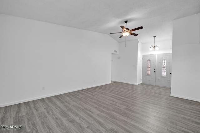 unfurnished living room featuring hardwood / wood-style floors, ceiling fan with notable chandelier, and lofted ceiling