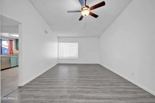 spare room featuring ceiling fan, light wood-type flooring, and sink