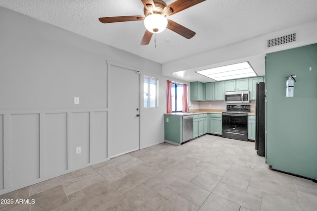 kitchen featuring black appliances, green cabinets, decorative backsplash, ceiling fan, and a textured ceiling