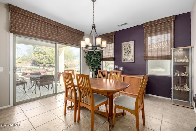 tiled dining room featuring an inviting chandelier