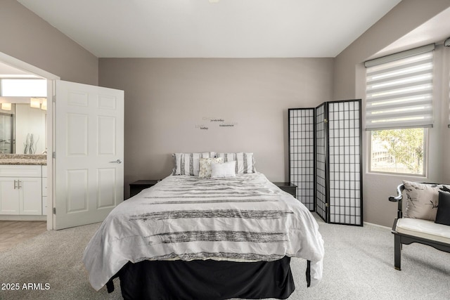 bedroom featuring light colored carpet and connected bathroom