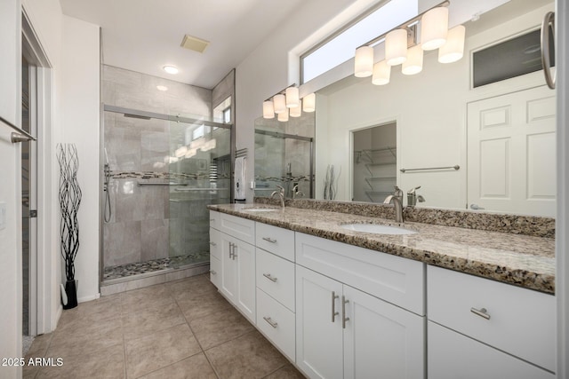 bathroom featuring a shower with door, vanity, and tile patterned flooring