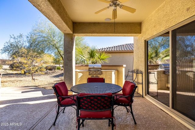 view of patio / terrace featuring area for grilling, ceiling fan, and exterior kitchen