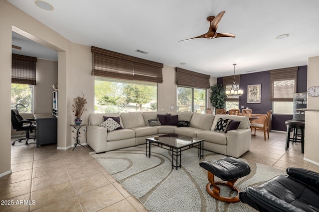 living room featuring ceiling fan with notable chandelier and light tile patterned floors