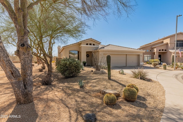 view of front of property featuring stucco siding, concrete driveway, an attached garage, and a tiled roof