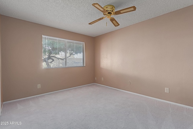 spare room with ceiling fan, light colored carpet, and a textured ceiling