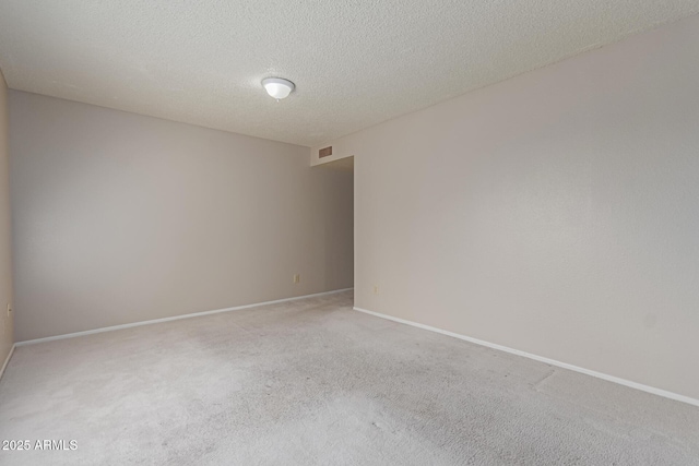 carpeted empty room with a textured ceiling