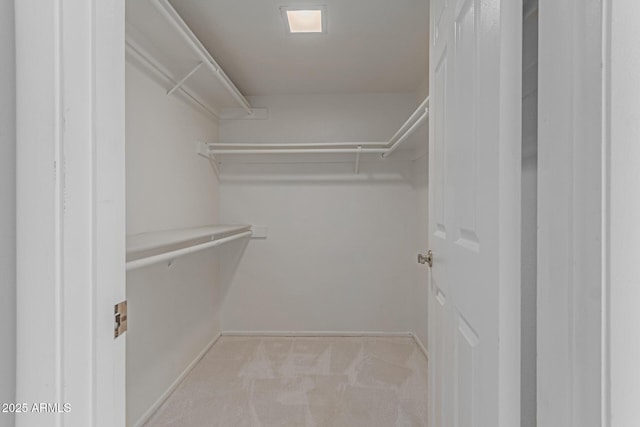 walk in closet featuring light colored carpet