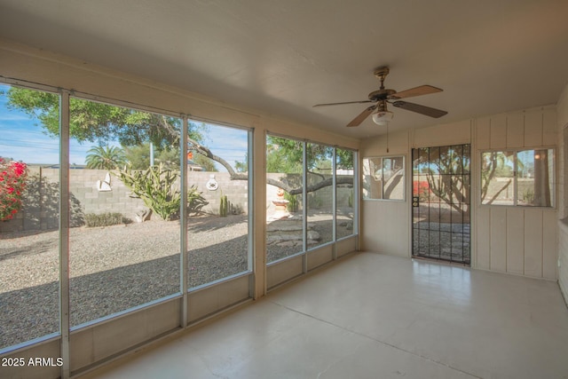 unfurnished sunroom with ceiling fan