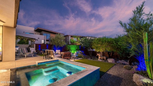 6525 E Cave Creek Rd Unit 40, Cave Creek, AZ 85331 - pool at dusk featuring an in-ground hot tub and a patio area