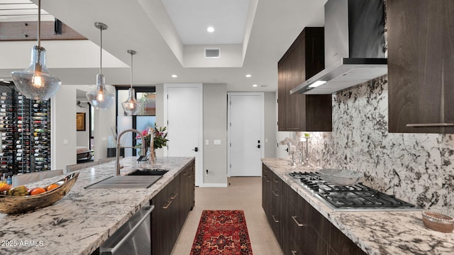 6525 E Cave Creek Rd Unit 40, Cave Creek, AZ 85331 - kitchen featuring wall chimney range hood, a sink, appliances with stainless steel finishes, decorative backsplash, and dark brown cabinets