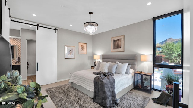 6525 E Cave Creek Rd Unit 40, Cave Creek, AZ 85331 - bedroom featuring a barn door, multiple windows, a chandelier, recessed lighting, and baseboards