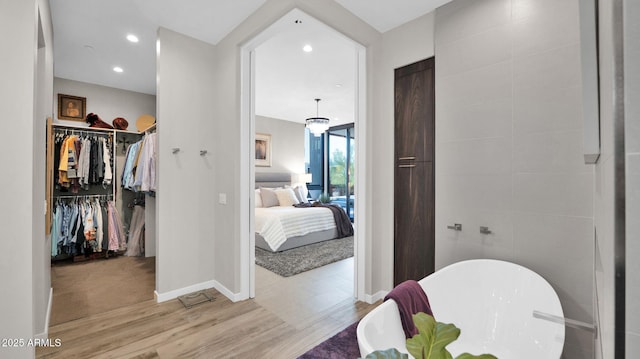 6525 E Cave Creek Rd Unit 40, Cave Creek, AZ 85331 - full bathroom with wood finished floors, a soaking tub, connected bathroom, a spacious closet, and baseboards