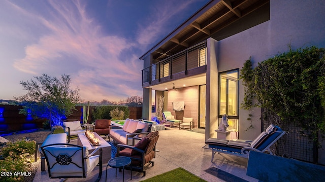 6525 E Cave Creek Rd Unit 40, Cave Creek, AZ 85331 - patio terrace at dusk featuring an outdoor living space with a fire pit, a balcony, and a patio