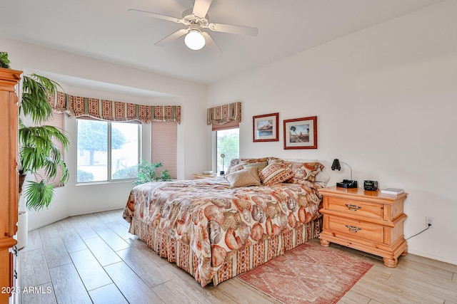 bedroom with ceiling fan, light hardwood / wood-style floors, and multiple windows