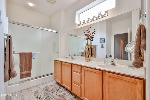 bathroom with vanity and a shower with shower door