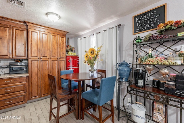 2022 W Aster Dr, Phoenix, AZ 85029 - dining space featuring a textured ceiling and light wood finished floors