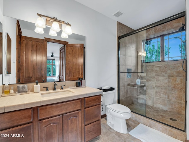 bathroom with a stall shower, visible vents, toilet, tile patterned flooring, and vanity