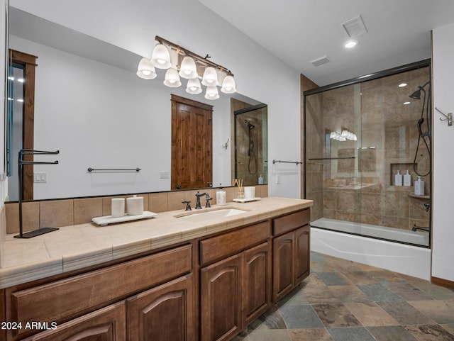 full bath with stone finish floor, enclosed tub / shower combo, visible vents, and vanity