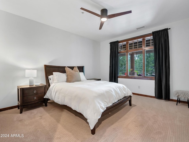 bedroom featuring baseboards, visible vents, a ceiling fan, and light colored carpet