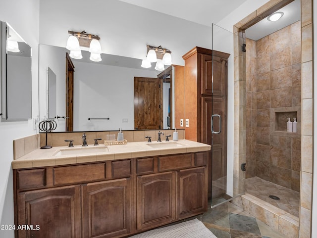 bathroom featuring a sink, a shower stall, and double vanity